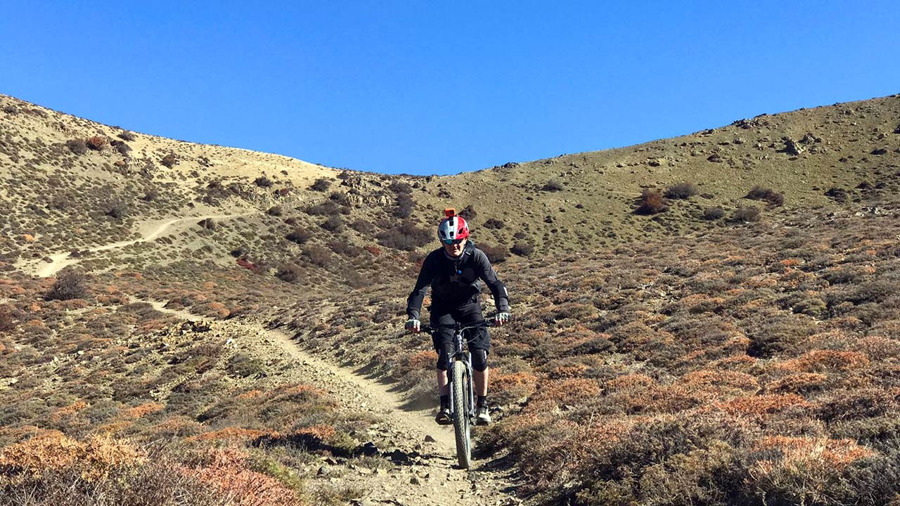 A mountain biker is enjoying his downhill ride in the Lupra single track of Mustang.