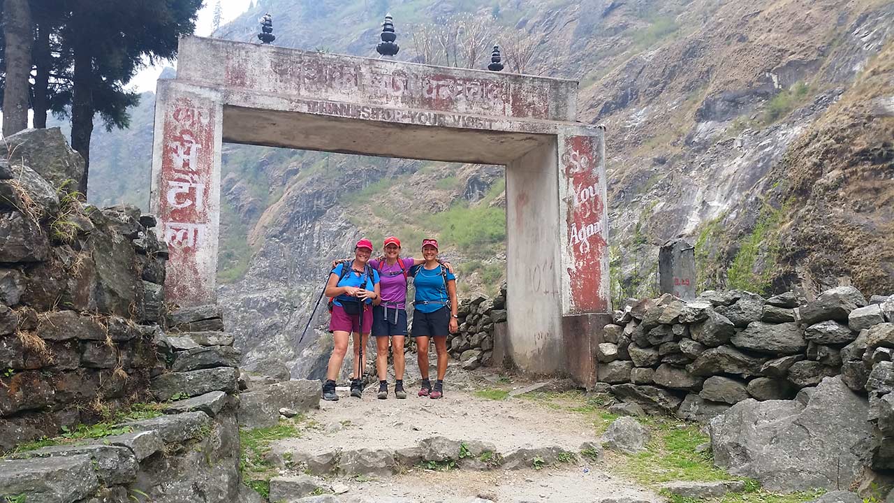 Three happy women posing to take picture with their arms on each others' shoulder at Taal in Manang.