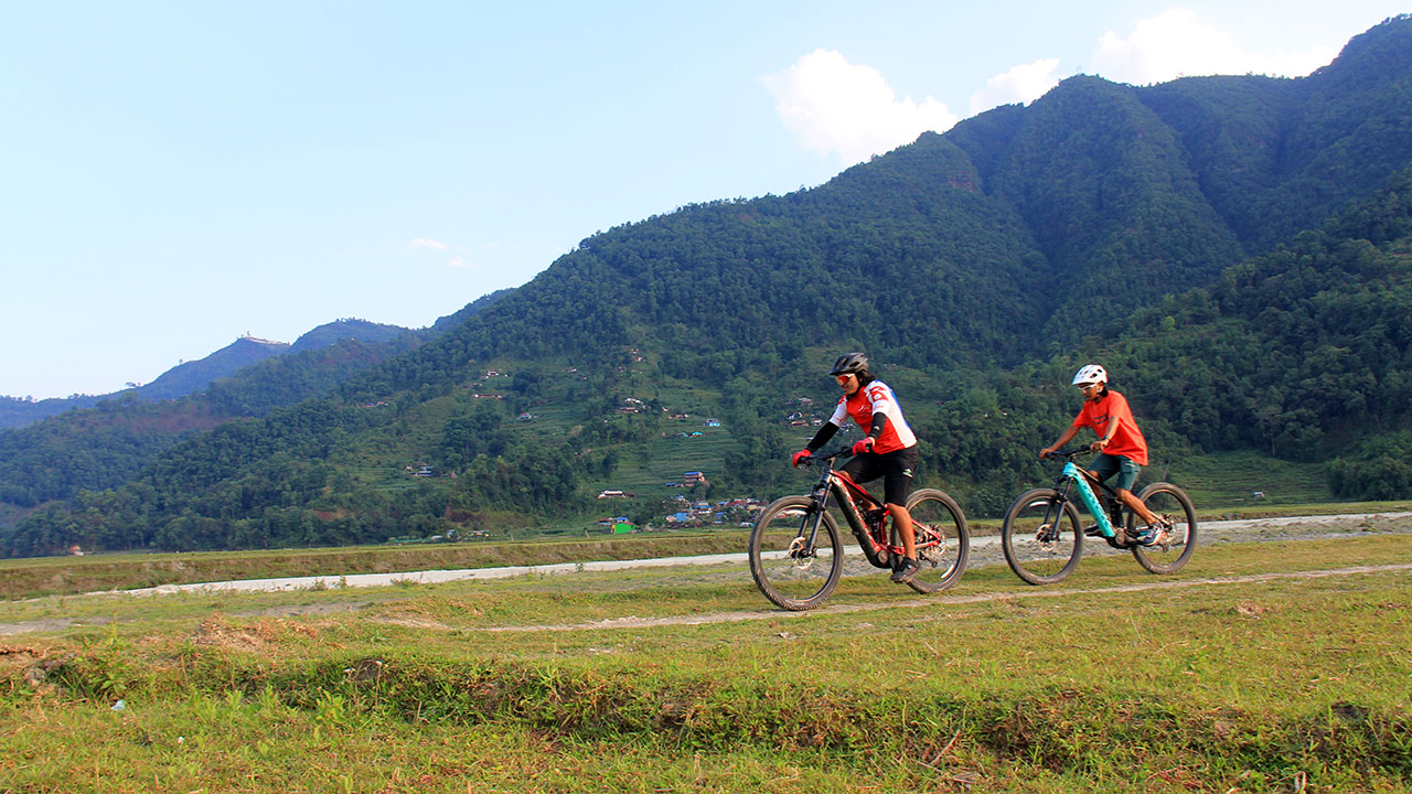 Two mountain bikers enjoyinng their ride along the river dyke in Pokhara