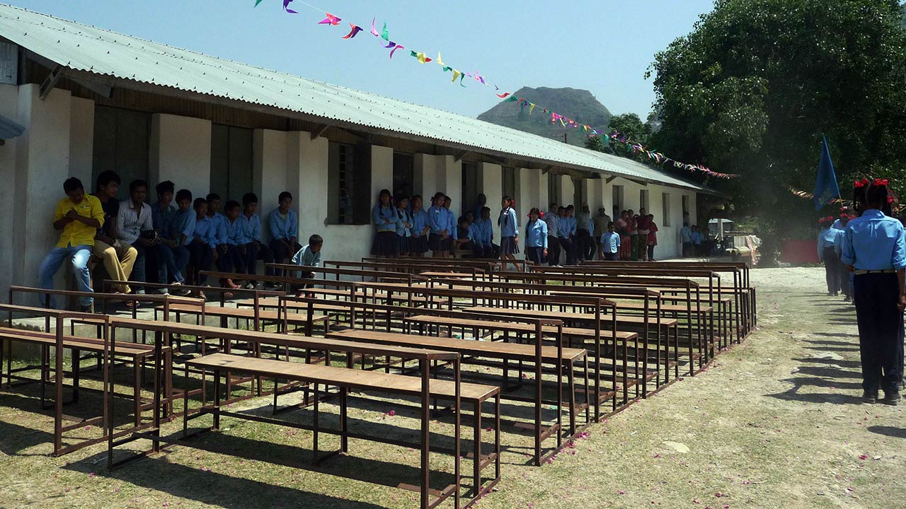 School kids in their uniform watching their new benches and desk provided by Pokhara Mountain Bike Adventure as a donation.