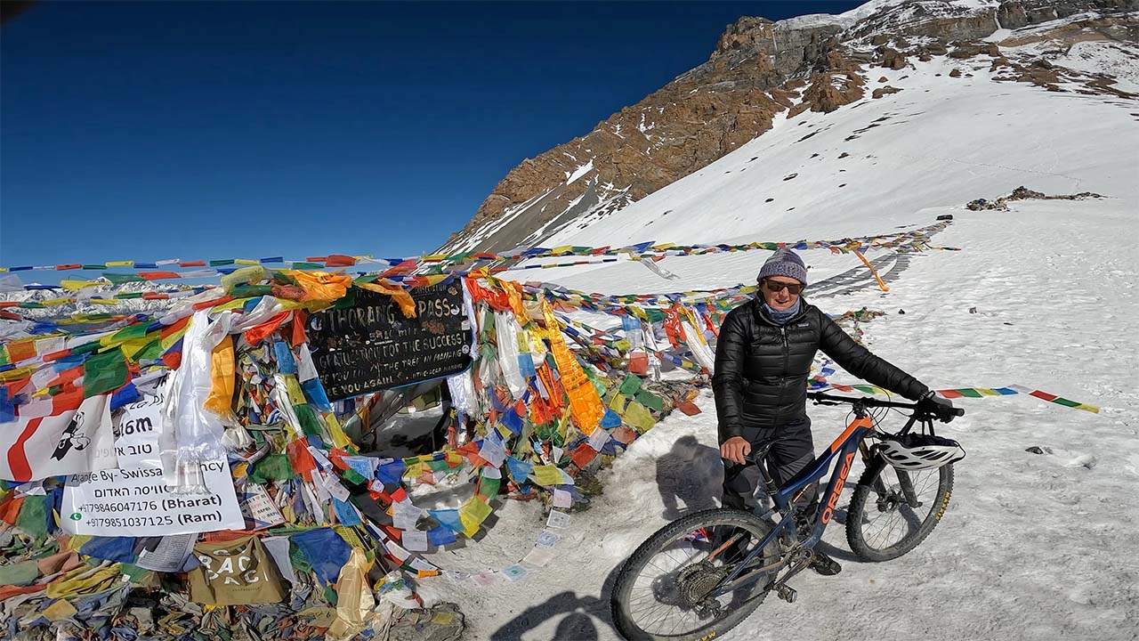 An Australian lady biker posing for a picture on the top of Thorong-La pass in Annapurna Circuit