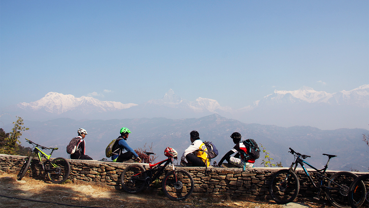 Group of mountain bikers enjoying the view of Annapurna range whilst taking rest near Peace Stupa.