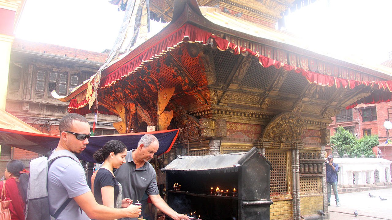 Foreigners are offering butter lamp in a Temple in Kathmandu.