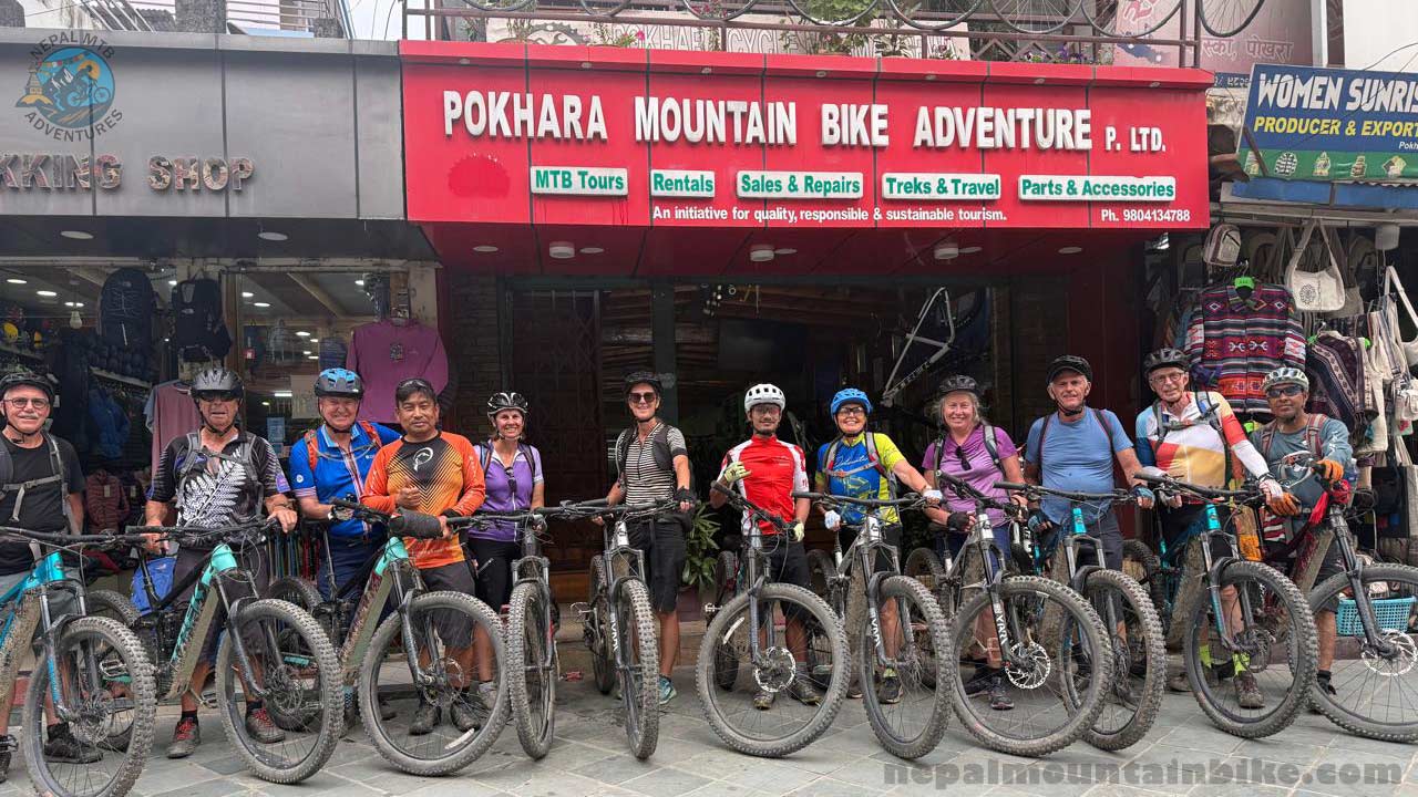 A group of E-MTB riders taking picture in front of the Pokhara Mountain Bike Adventure store during the Nepal E-MTB Guided tour.