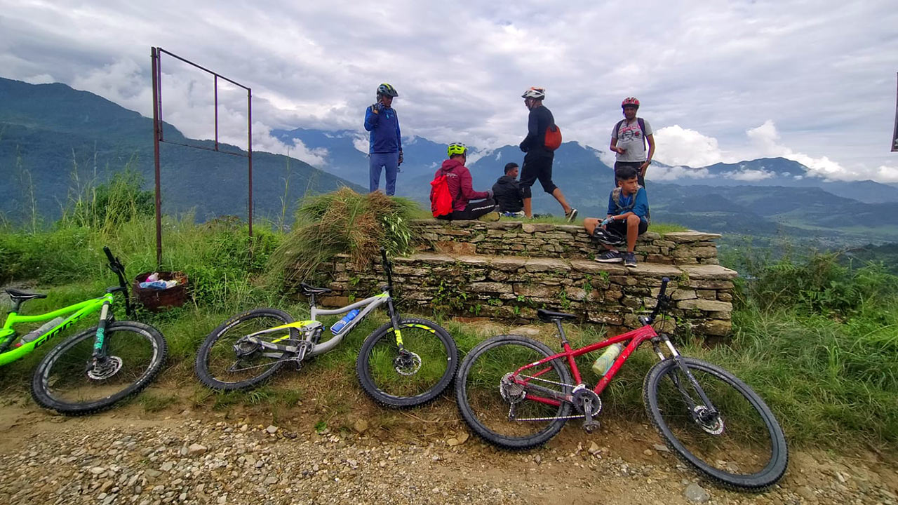 Mountain bikers are taking rest while their bikes are laid down on the ground.