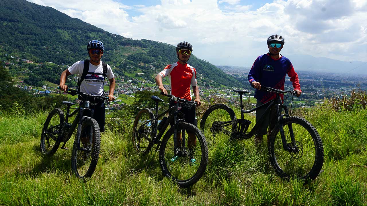 Mountain bikers are taking picture with their mountain bikes with the background of Kathmandu valley in Nepal.