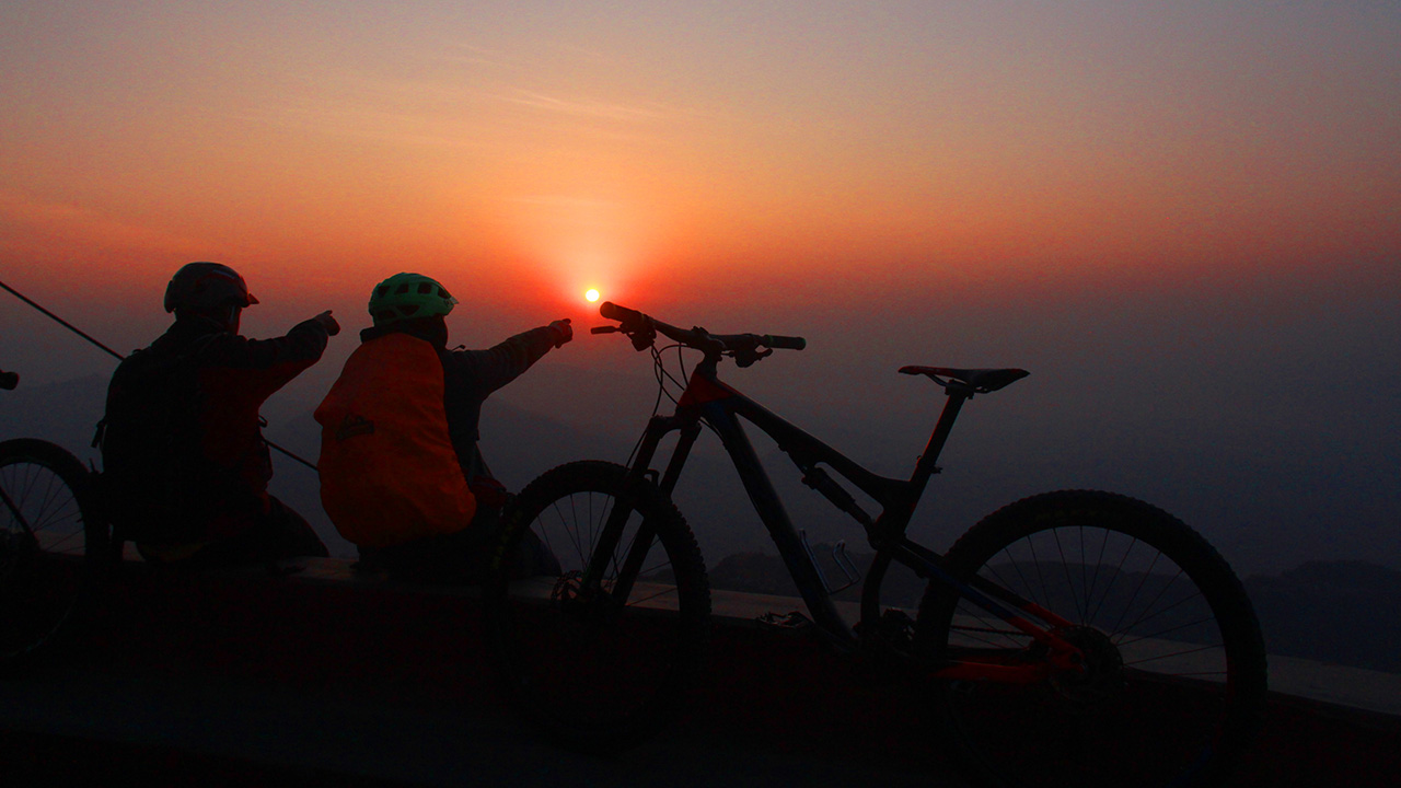 Bikers are cheering the sunrise view from Sarangkot with their bikes kept on each sides.