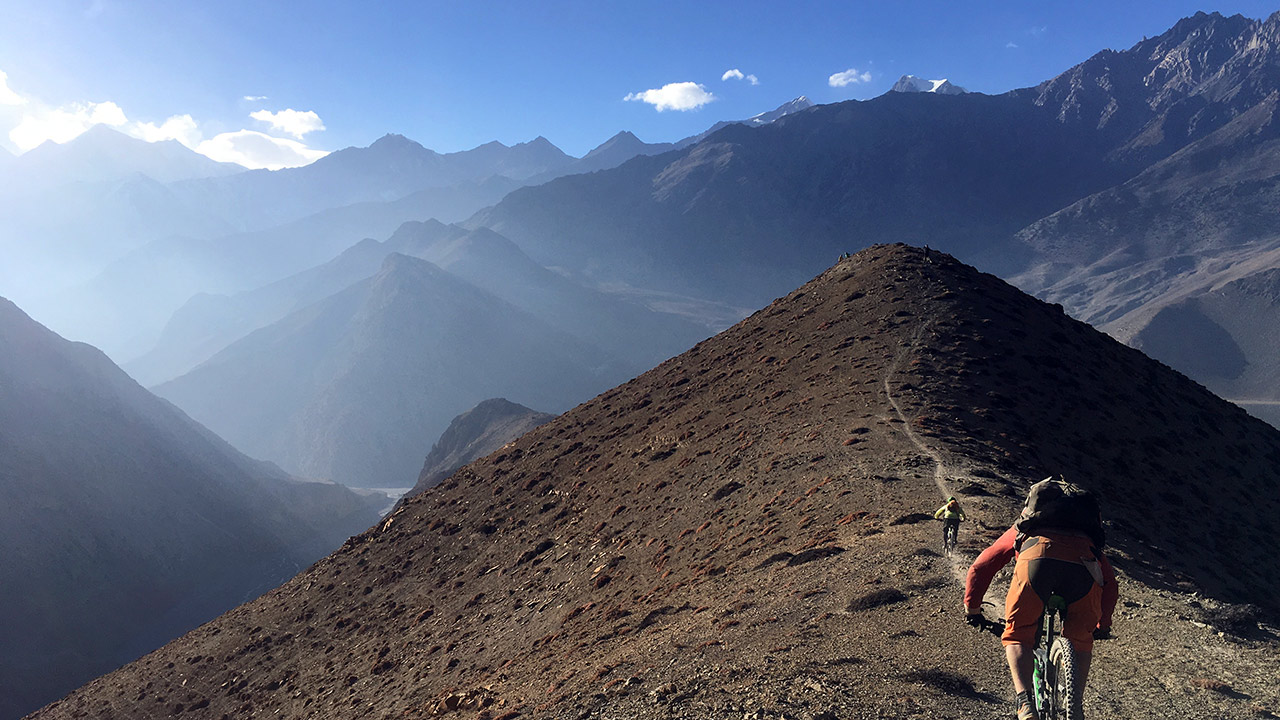 Two mountain bikers are rolling down through Lupra single trail.