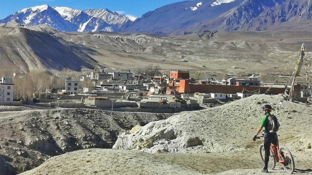 A mountain biker is observing the walled city of Lo-Manthang in upper Mustang.